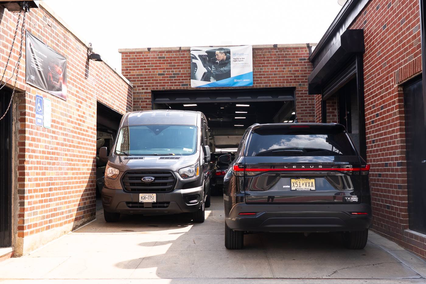Metro Auto Body service vehicles and customer cars parked outside the Corona, NY collision center