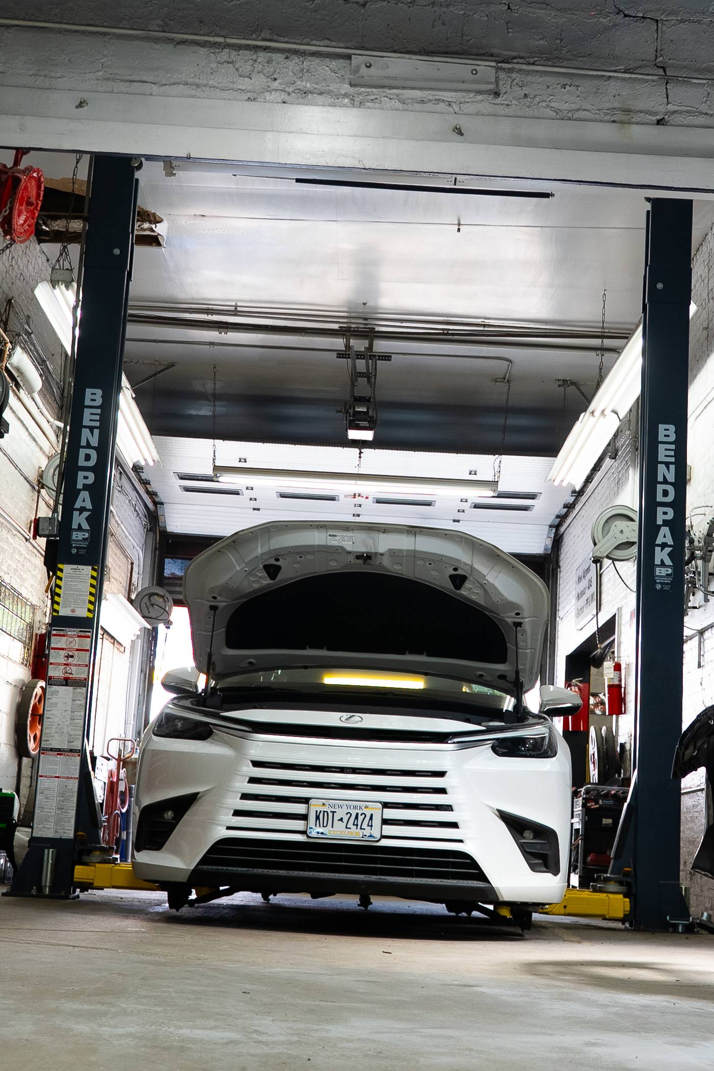 Lexus sedan raised on a BendPak lift for undercarriage collision repair inspection